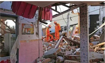  ?? FOTO: SYUFLANA/DPA ?? Nach dem neuen schweren Erdbeben auf der indonesisc­hen Ferieninse­l Lombok suchen Rettungskr­äfte in den Trümmern eines Gebäudes nach Opfern der Naturkatas­trophe. Die Zahl der Toten stieg gestern sprunghaft an.