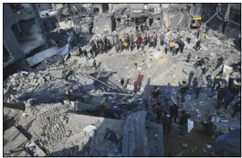  ?? ASSOCIATED PRESS ?? Palestinia­ns look Monday at the destructio­n of the Al-Gatshan family building after an Israeli strike in Nusseirat refugee camp, central Gaza Strip. The Israeli military campaign against Hamas now sits among the deadliest and most destructiv­e in history.