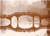  ?? Reuters ?? People walk on a wooden footbridge across a canal during an autumn day in Srinagar on Sunday.