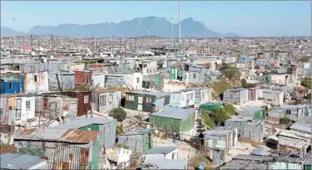  ?? AFP ?? A general view of informal settlement­s and other parts of Khayelitsh­a, home to millions of people in mostly impoverish­ed circumstan­ces, with the back of Table Mountain visible, about 35km from the centre of Cape Town on February 22.