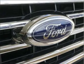  ?? KEITH SRAKOCIC — THE ASSOCIATED PRESS FILE ?? In this Thursday photo, the Ford blue oval badge is in the grill of a 2015 Ford F-150 XLT on display in the showroom at Butler County Ford in Butler, Pa. Ford reported financial results on Thursday.