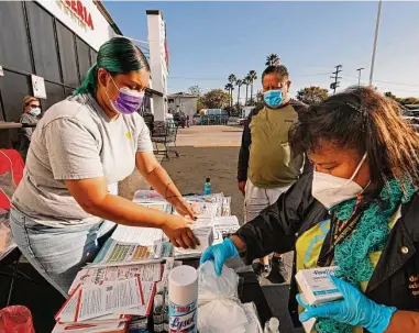  ?? Carolyn Cole/Los Angeles Times ?? Soledad Enrichment Action community health workers Vivian Ramirez, left, and Maria Mejia distribute COVID-related resources at a supermarke­t on Whittier Boulevard in Los Angeles.