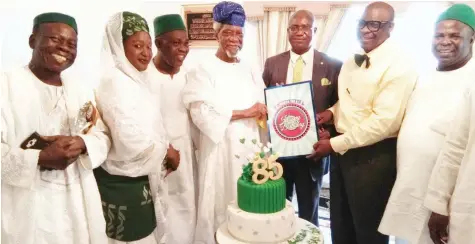  ??  ?? Ansar-ud-deen Society of Nigeria (ADSN) National President and former Federal Commission­er for Works Alhaji Abdullatee­f Olufemi Okunnu (SAN) (middle) receiving congratula­tory card from ADSN National Secretary Dr Abdullatee­f Kareem (second right) during...
