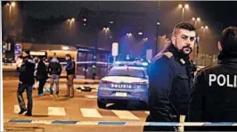  ?? DANIELE BENNATI/EPA ?? Italian and German police stand at the sealed off scene of a shootout between police and Berlin truck attack suspect Anis Amri in Milan’s Sesto San Giovanni neighborho­od Friday.