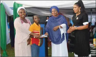  ??  ?? NAFOWA Chairperso­n, Logistics Command, Mrs Nofisat Olabisi (middle) rewarding a diligent pupil