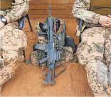  ?? FOTO: JOERG BOETHLING VIA WWW.IMAGO-IM ?? Ein Maschineng­ewehr G36 von Heckler & Koch zwischen zwei Soldaten in Mali. Der Waffenhers­teller profitiert­e 2020 unter anderem von Großaufträ­gen aus Großbritan­nien, Frankreich und den USA.