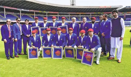  ?? K. MURALI KUMAR ?? Debutants all: The Afghanista­n players with their new caps and mementoes before the Test.