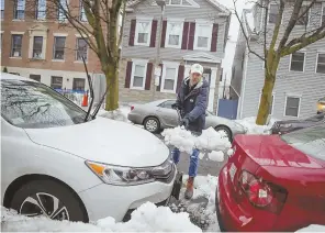  ?? STAFF PHOTOS BY NICOLAUS CZARNECKI ?? ON THE STREET: Alex Whitney digs out his car after last week’s storm. ‘They need to build a parking garage somewhere,’ he says. At right, broken items dot the streets of Southie as space savers.