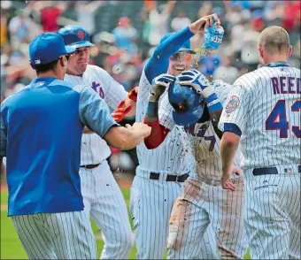  ?? SETH WENIG/AP PHOTO ?? The Mets’ Jose Reyes, center, is mobbed by teammates after hitting a walk-off RBI single during the ninth inning of Thursday’s game against St. Louis at Citi Field. The Mets won, 3-2.