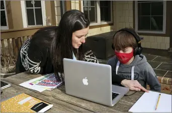  ?? LEAH WILLINGHAM — THE ASSOCIATED PRESS ?? Angela Atkins helps her son Jess Atkins work on a math problem on his laptop during home schooling in Oxford, Miss., on Dec. 18. Angela Atkins has been home schooling Jess and his brother, Billy, since October, after they struggled with remote learning at their public school.