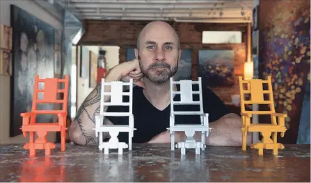  ?? SCOTT GARDNER THE HAMILTON SPECTATOR ?? Local multimedia artist Stev'nn Hall has used 3D printers at the Hamilton Public Library’s Makerspace to create small electric chairs as templates for larger pieces he plans to create for an art show in Los Angeles next year. The printers can turn spools of coloured plastic into small objects.