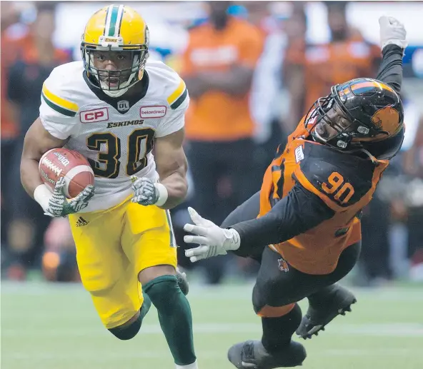 ?? — THE CANADIAN PRESS FILES ?? Edmonton running back John White, left, scampers away from Lions defender Mic’hael Brooks during the season-opener at B.C. Place back in June. White ran for 104 yards and a touchdown on 17 carries as the Eskimos edged the Lions 30-27.