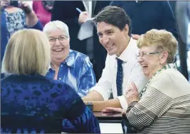  ?? CP PHOTO ?? Prime Minister Justin Trudeau drops in on a card game at St. Margaret’s Church during a visit to Fredericto­n yesterday.