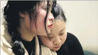  ?? Liu Hongbin For The Times ?? ESTHER RESTS HER HEAD on Shuangjie’s shoulder during their last day together. During Esther’s weeklong visit, the girls advanced from awkward formality to thoughts of future visits.