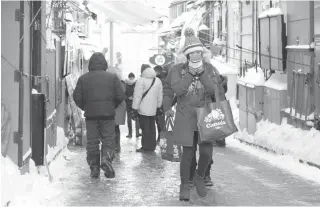  ??  ?? DEEP FREEZE
People walk down an icy street in Quebec City, Canada on December 27, 2017. In Canada, extreme cold warnings were issued for scores of communitie­s across the country, including the heavily populated provinces of Ontario and Quebec. While...