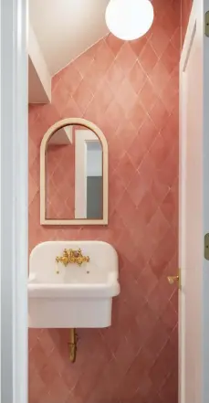  ??  ?? |TOP RIGHT| PRETTY IN PINK. The downstairs powder room features pink diamond tiles with a glazed terracotta style from Crossville Inc., which makes a big statement in this tiny space.
