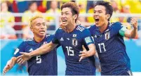  ?? JACK GUEZ/AFP/GETTY IMAGES ?? Japan’s Yuya Osako, centre, celebrates his winning goal with Yuto Nagatomo, left, and Makoto Hasebe. It was the first time in 18 tries that an Asian team won against a South American team.