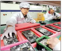  ?? AP file photo ?? Foxconn production line employees work in a factory in the southern Chinese city of Shenzhen in 2010. Plans for Foxconn to build a $10 billion factory in Wisconsin were announced Wednesday in Washington.