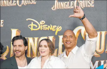  ?? Chris Pizzello The Associated Press file ?? Actor Dwayne Johnson, star of the adventure movie “Jungle Cruise,” flashes the Hawaiian “shaka” hand sign — notice, palm forward — alongside fellow cast members Edgar Ramirez and Emily Blunt at the 2021 premiere at Disneyland in Anaheim, Calif.