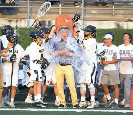  ?? Haley Nelson/Post-Gazette photos ?? Mars Area High School's boys lacrosse team dumps water on coach Bob Marcoux after winning the WPIAL Class 2A championsh­ip over Quaker Valley.