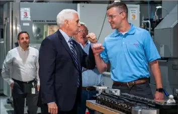  ?? Steph Chambers/Post-Gazette ?? Vice President Mike Pence elbow-bumps machinist Shane Peters during a tour Friday at Oberg Industries near Sarver.