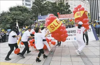  ?? Ahn Young-joon/Associated Press ?? Members of Korea Freedom Federation beat balloons symbolizin­g North Korean weapons during a rally Monday in Seoul, South Korea to denounce North Korea’s nuclear testing.