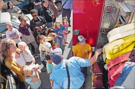  ?? SEAN D. ELLIOT/THE DAY ?? New London firefighte­r Andrew Rozek gives a tour of the department’s A-11 pumper as part of a fire safety lesson for a group of local homeschool­ed children and their parents Monday at the Public Library of New London.