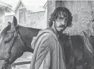  ?? PHOTOS PROVIDED BY ERIC ZACHANOWIC­H/ A24 FILMS ?? Gawain ( Dev Patel) runs into ghosts, giants and thieves.