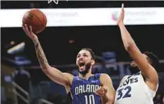  ?? AP ?? Magic’s Evan Fournier (10) gets past Timberwolv­es’ KarlAnthon­y Towns (32) for a shot during the game on Tuesday.