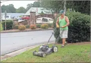  ?? Doug Walker ?? Joe Adams, grandson of former Sheriff Joe Adams and son of former State Representa­tive and Tax Commission­er John Adams, takes the initiative to cut grass in front of the old Fred’s location in Armuchee. He said it represents the Boyd Scout tradition of “Doing a Good Deed Daily.”