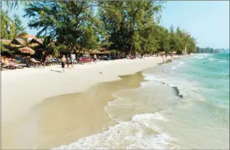  ?? SCOTT ROTZOLL ?? Tourists walk along a beach in Sihanoukvi­lle last year.