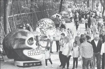  ??  ?? Cientos de visitantes recorren Paseo de la Reforma para admirar la instalació­n Mexicráneo­s, como preámbulo al desfile de Muertos que se realizará este sábado ■ Foto Víctor Camacho
