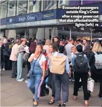  ?? PA ?? Evacuated passengers
outside King’s Cross after a major power cut that also affected traffic
lights(left)