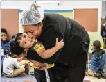  ?? ALYSSA POINTER / AJC ?? Little Ones learning center cook Josefa Martinez kisses her son. “For me, for my family, it’s been important” to have PeachCare. “If you don’t have any insurance, you don’t go to the doctor.”