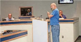  ?? [PHOTOS BY THOMAS MAUPIN, THE OKLAHOMAN] ?? John Hanes tells the Moore City Council about what he says are parking problems on S Silver Leaf Drive. Listening in the background are Councilmen Terry Cavnar, left, and Mark Hamm.