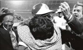 ?? AP 1974 ?? Tom House (right, in glasses) has the record-setting home run ball in his left hand to give to Hank Aaron, who is being embraced by his mother, Estella, at home plate. Aaron’s father, Herbert, is on the left trying to hold on to his hat.