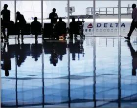  ?? (AP) ?? A Delta Air Lines jet sits at a gate at Hartsfield-Jackson Atlanta Internatio­nal Airport.