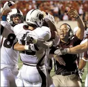  ?? Democrat-Gazette file photo ?? Louisiana-Monroe’s Kolton Browning (center) is mobbed by teammates and coaches after scoring the winning touchdown in the Warhawks’ upset victory over No. 8 Arkansas in 2012.