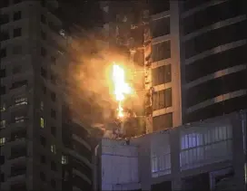  ?? KAMRAN JEBREILI / ASSOCIATED PRESS ?? Smoke and flames shoot out from the Torch Tower in the Marina district of Dubai, United Arab Emirates, on Friday. The blaze broke out about 1 a.m. Friday in one of the world’s tallest residentia­l towers, engulfing part of the skyscraper and sending...