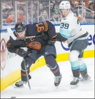  ?? Jason Franson The Associated Press ?? Oilers center Connor Mcdavid and Kraken defenseman Ryker Evans vie for the puck in Edmonton’s win Thursday at Rogers Place.