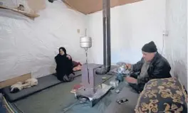  ?? HUSSEIN MALLA/AP ?? Mohammed Zakaria, right, fled his Syrian hometown of Homs in 2012. He sits with one of his wives March 5 at a refugee camp in the Bekaa Valley in eastern Lebanon.