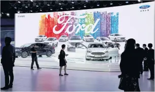 ??  ?? LEFT Visitors look at Ford models at Auto Guangzhou on November 17, 2017.
