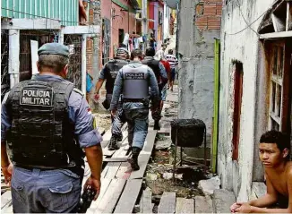  ?? Edmar Barros/Folhapress ?? Policiais no bairro em Manaus após madrugada em que 17 morreram
