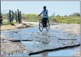  ?? Picture: RIAAN MARAIS ?? WET WHEELS: A cyclist rides through puddles in Shuttle Street, Uitenhage