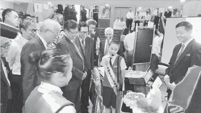  ??  ?? BERI GALAKAN: Abang Johari dan Manyin mendengar penerangan pelajar SJKC Chung Hua Krokop yang terlibat dalam pameran semasa Simposium Pendidikan Bahasa Inggeris Sarawak di Miri semalam.