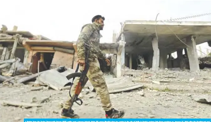  ??  ?? A fighter from the Syrian Democratic Forces (SDF) walks past a former Islamic State (IS) group jihadist alms tax centre in the city of Hajin in Syria’s eastern Deir Ezzor province on January 27, 2019 after the Kurdish-led and US-backed SDF retook the city from IS fighters. — AFP