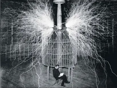  ?? STEFANO BIANCHETTI / GETTY ?? El inventor e ingeniero eléctrico croata Nikola Tesla, sentado junto a una jaula de Faraday