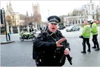  ??  ?? Armed policemen respond outside parliament during the attack on Westminste­r Bridge. —