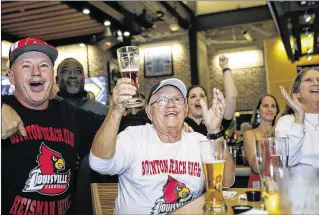  ?? PHOTOS BY YUTING JIANG / THE PALM BEACH POST ?? Bill Tomé (left) and his father, William, celebrate Lamar Jackson’s winning of the Heisman Trophy on Saturday night at a Buffalo Wild Wings in Boynton Beach. “We knew he would do something great,” Tomé said at the restaurant. “We just didn’t know when.”