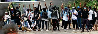  ??  ?? DEFIANCE: Anti-coup protesters raise the three-finger salute, a gesture of resistance, during a demonstrat­ion in Yangon